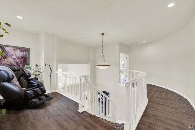 hallway with wood finished floors, an upstairs landing, and recessed lighting