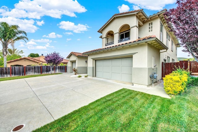 mediterranean / spanish home with fence, a tiled roof, stucco siding, an attached garage, and driveway