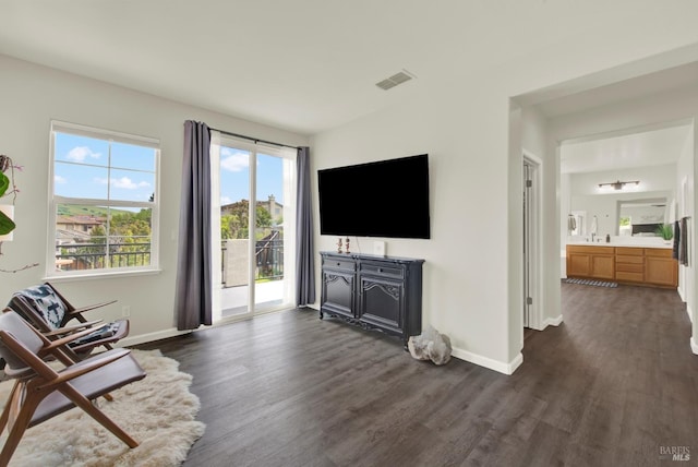living room with baseboards, visible vents, and dark wood-style floors