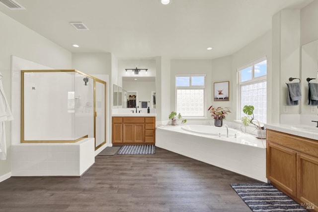 bathroom with a shower stall, visible vents, a garden tub, and wood finished floors