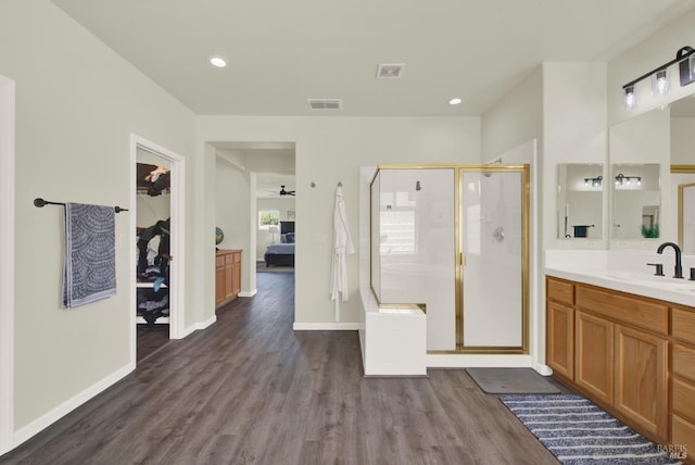 ensuite bathroom featuring a stall shower, ensuite bathroom, visible vents, wood finished floors, and vanity
