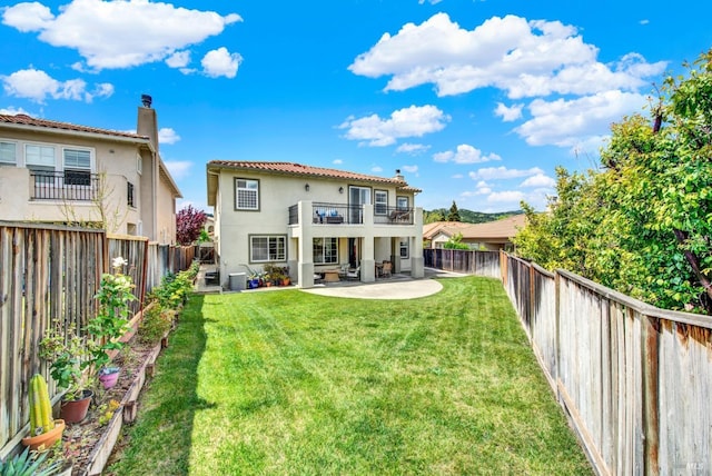 back of property with a patio, a lawn, a chimney, and stucco siding