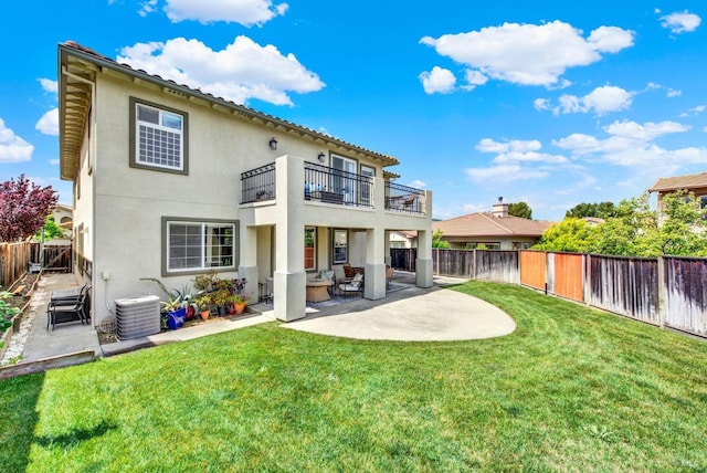 rear view of property with a balcony, central air condition unit, a fenced backyard, a yard, and stucco siding