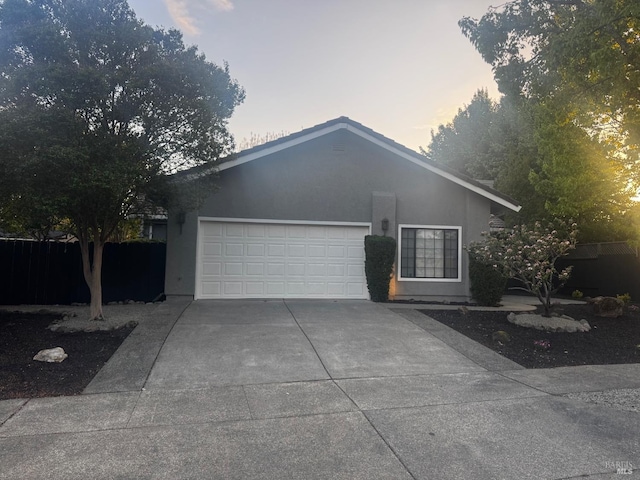 single story home featuring stucco siding, driveway, and a garage