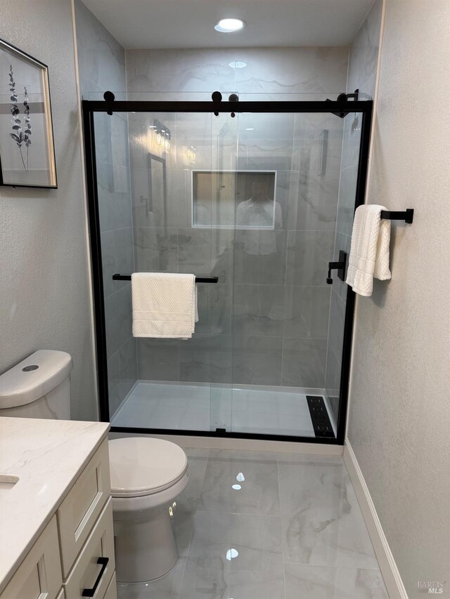 4187 Tokay Dr, Napa, CA 94558 - bathroom featuring marble look tile flooring, toilet, vanity, baseboards, and a textured wall