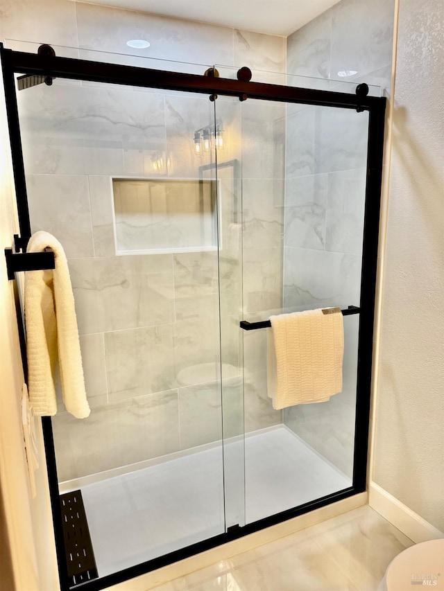 bathroom featuring baseboards and a shower stall