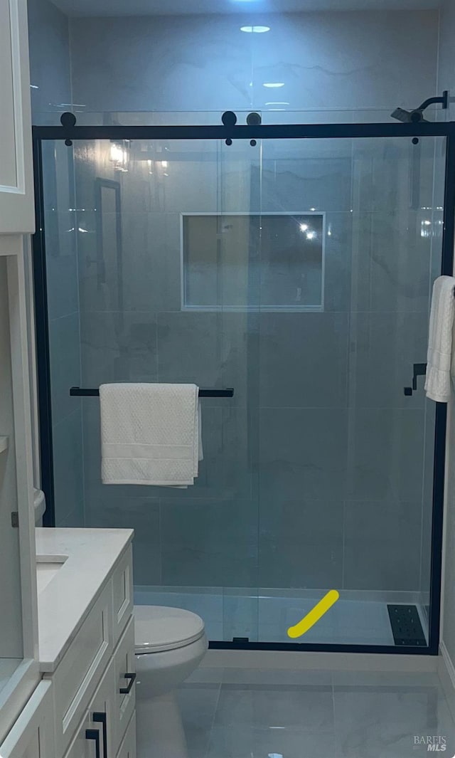 full bath featuring vanity, marble finish floor, a stall shower, and toilet