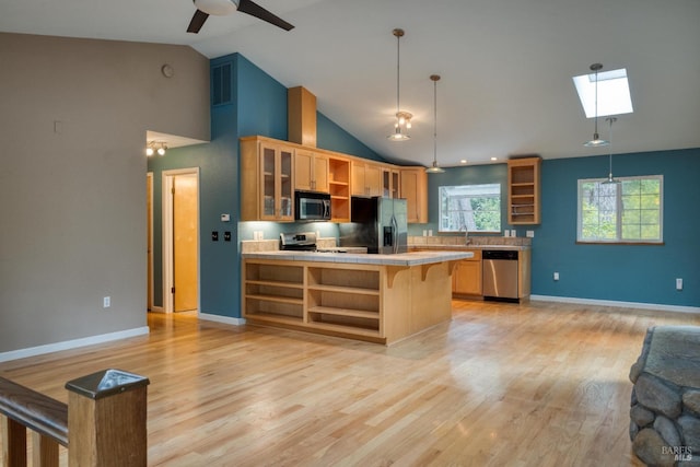 16589 Glenda Dr, Guerneville, CA 95446 - kitchen featuring open shelves, stainless steel appliances, tile countertops, a skylight, and a peninsula