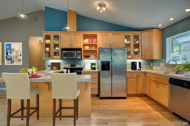 16589 Glenda Dr, Guerneville, CA 95446 - kitchen with stainless steel appliances, tile countertops, light wood-style floors, a breakfast bar, and high vaulted ceiling