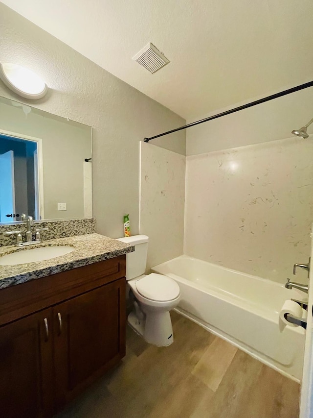 full bath with wood finished floors, vanity, tub / shower combination, toilet, and visible vents