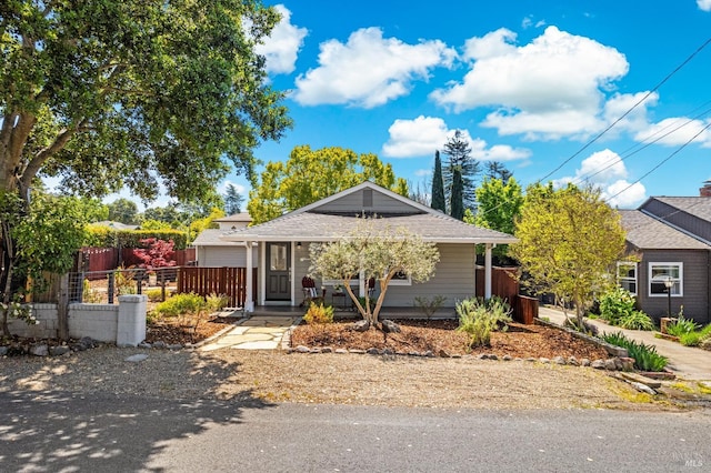 single story home featuring covered porch and fence