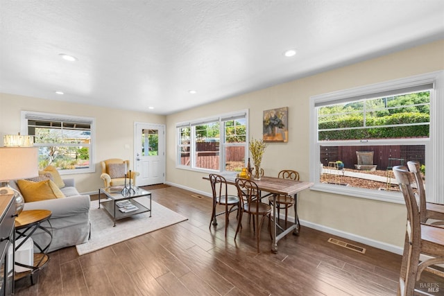 living room featuring baseboards, wood finished floors, and visible vents