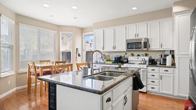 1220 Bello Dr, Dixon, CA 95620 - kitchen with light wood-type flooring, stainless steel appliances, a sink, and dark stone counters