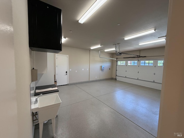 garage with a garage door opener and a sink