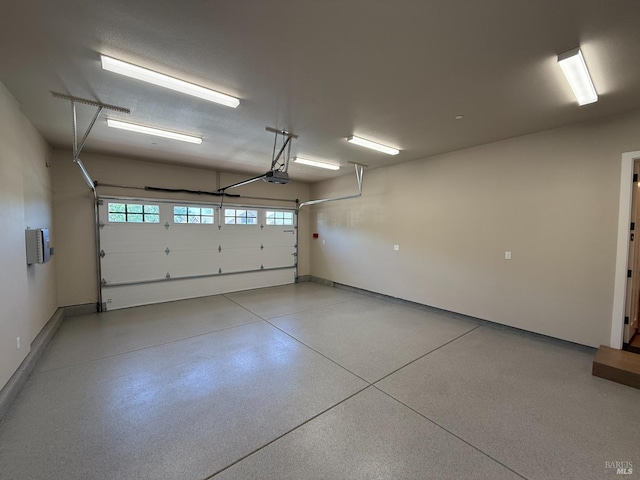 garage featuring a garage door opener and baseboards
