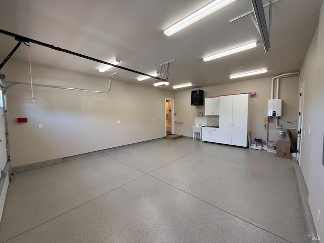garage with tankless water heater, a garage door opener, baseboards, and a sink