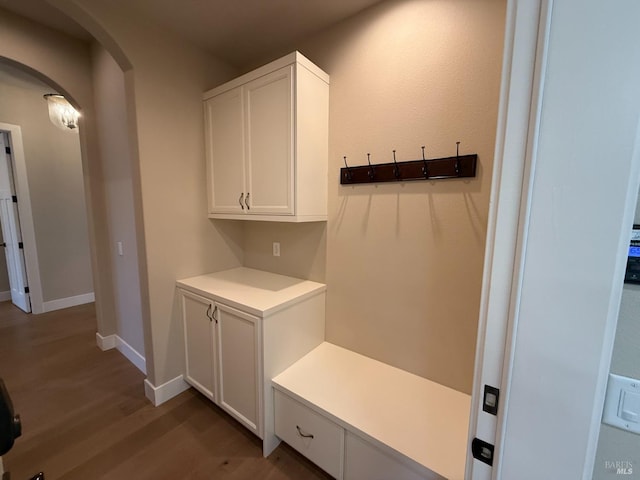 mudroom with wood finished floors, baseboards, and arched walkways