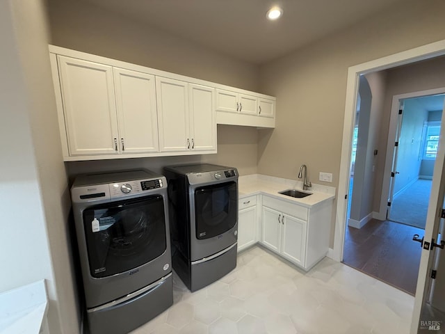 washroom with recessed lighting, a sink, washing machine and clothes dryer, and cabinet space