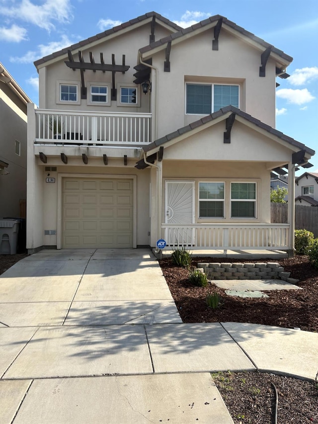 view of front of home featuring a porch, a garage, a balcony, concrete driveway, and stucco siding
