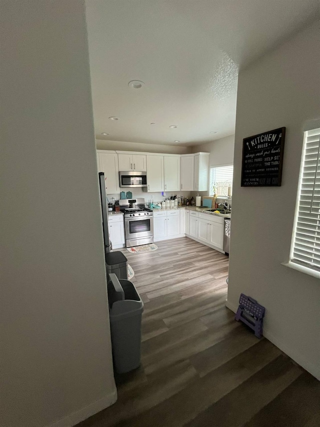 interior space featuring white cabinetry, appliances with stainless steel finishes, recessed lighting, and light wood-type flooring
