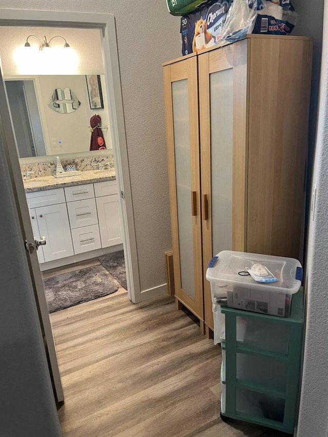 bathroom featuring a textured wall, wood finished floors, and vanity