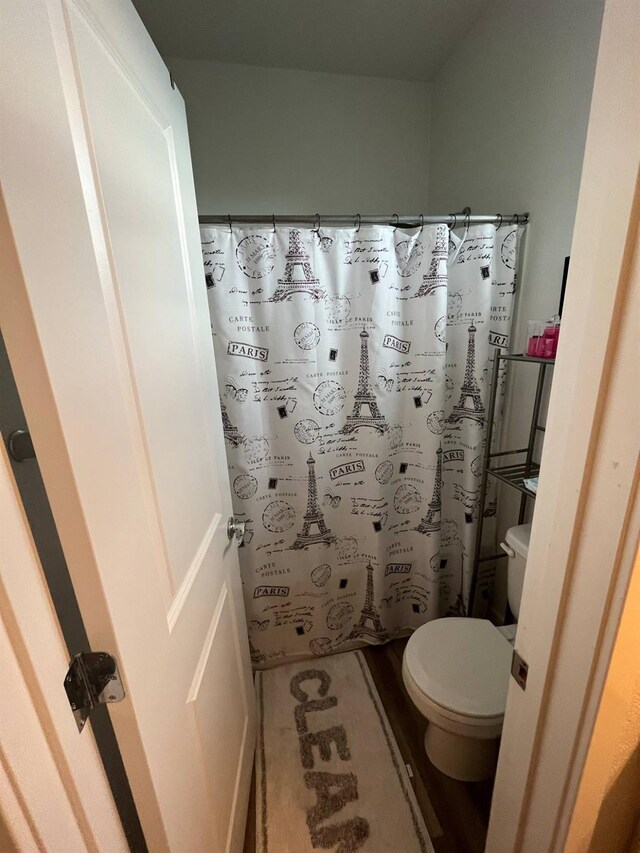 full bathroom featuring toilet and curtained shower