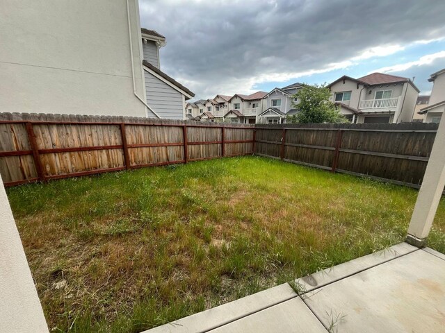 view of yard featuring a fenced backyard and a residential view