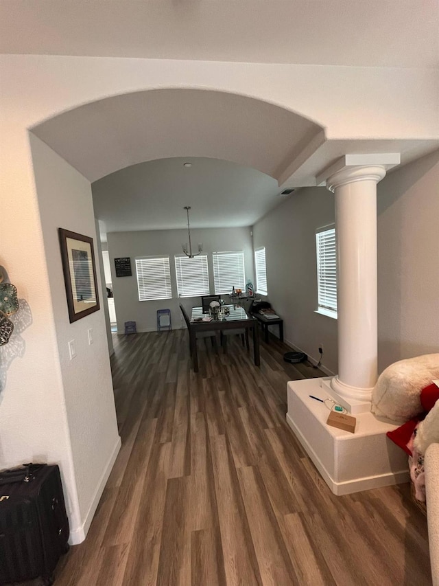 dining room featuring arched walkways, decorative columns, visible vents, and dark wood-type flooring