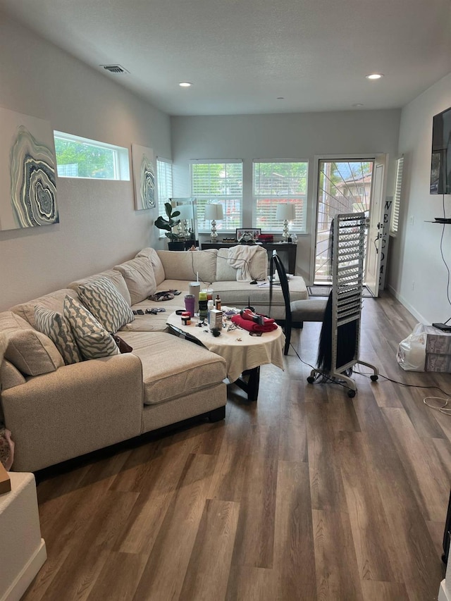 living room with recessed lighting, wood finished floors, and visible vents