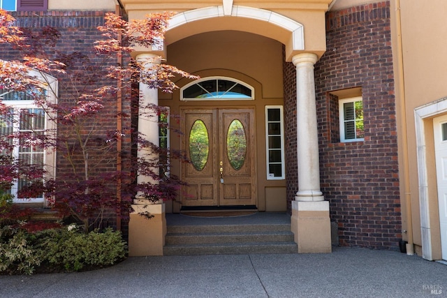 view of exterior entry featuring brick siding