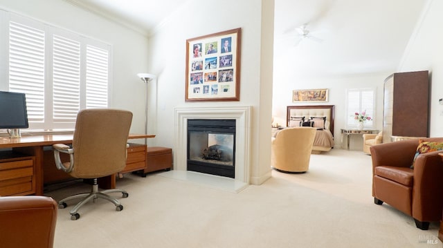 office area with a ceiling fan, a glass covered fireplace, carpet flooring, and crown molding