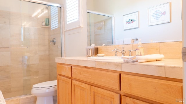 full bath featuring toilet, vanity, and a stall shower