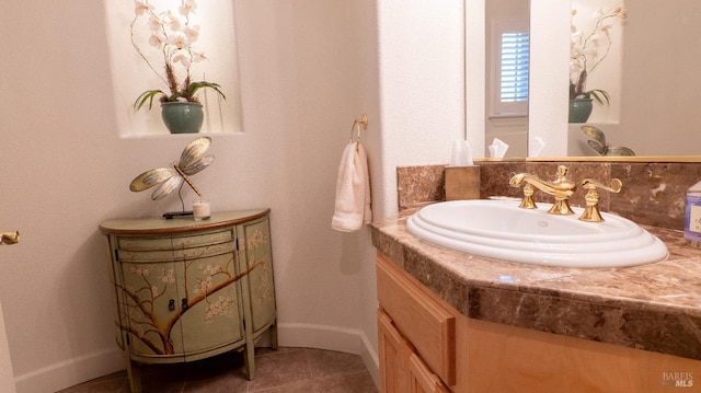 bathroom featuring baseboards, tile patterned flooring, and vanity