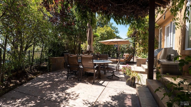 view of patio with outdoor dining area and fence