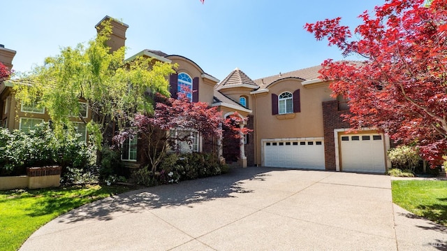 view of front facade featuring an attached garage, a tile roof, driveway, and stucco siding
