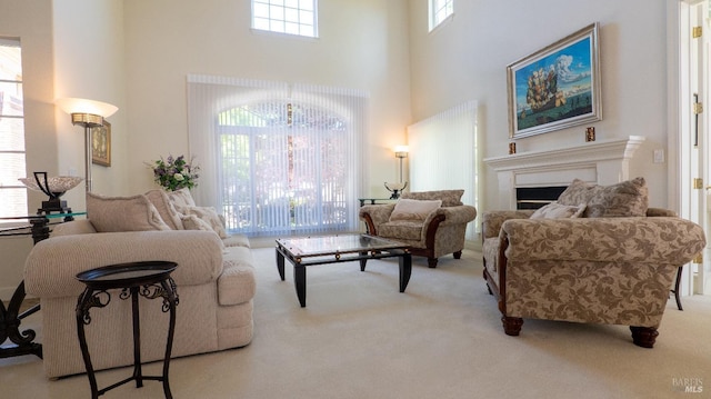 carpeted living room with a high ceiling and a fireplace