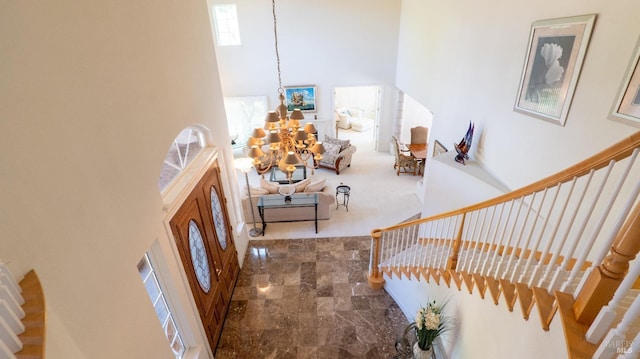 foyer with stairs, a high ceiling, and a notable chandelier