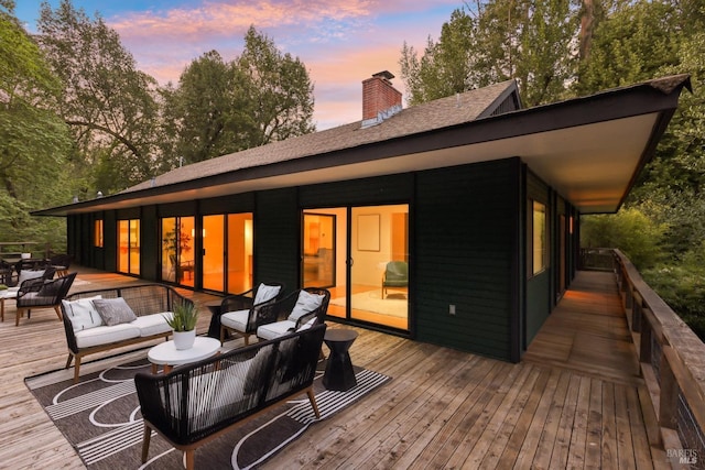 deck at dusk featuring an outdoor hangout area