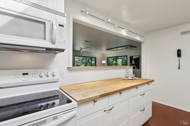 kitchen with wood counters, white appliances, white cabinets, baseboards, and visible vents