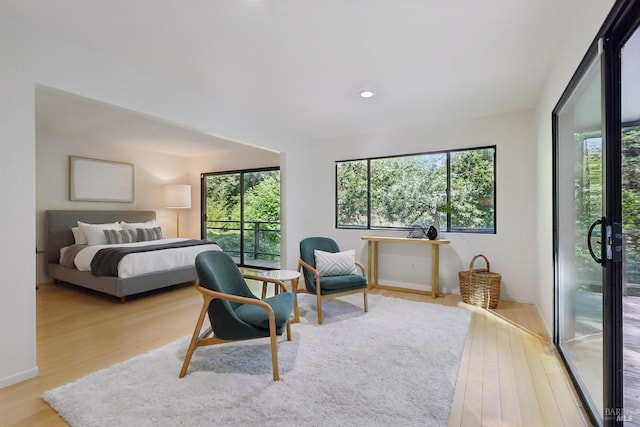 bedroom featuring access to outside, wood finished floors, and recessed lighting