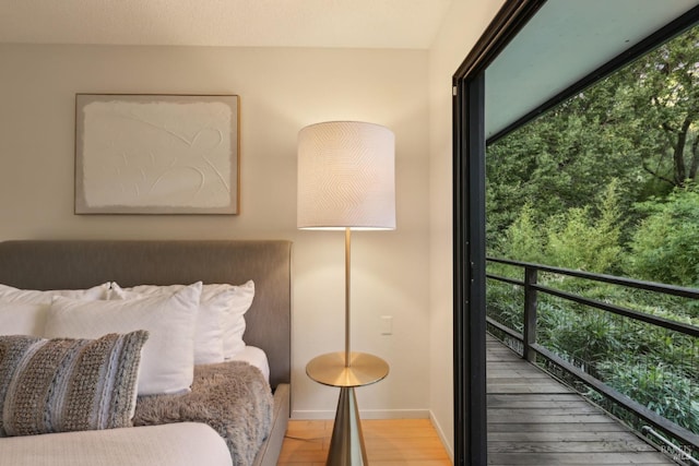 bedroom featuring wood finished floors, baseboards, and multiple windows
