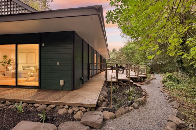 property exterior at dusk with a wooden deck