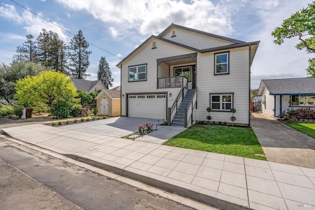 view of front of property featuring stairway, concrete driveway, an attached garage, an outbuilding, and a storage unit
