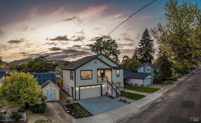 view of front of home with stairway, concrete driveway, an outdoor structure, a storage unit, and a garage