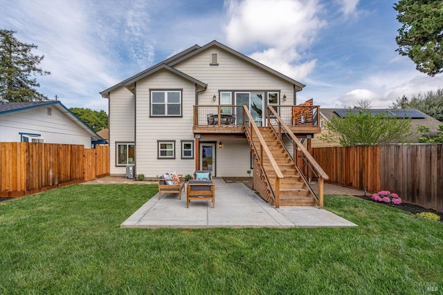 back of property with a fenced backyard, a wooden deck, stairs, a yard, and a patio