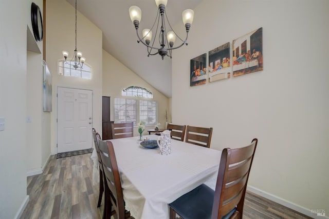 dining room featuring high vaulted ceiling, baseboards, wood finished floors, and a chandelier