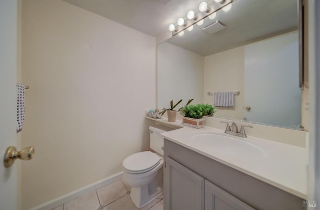 half bath with tile patterned floors, baseboards, vanity, and toilet