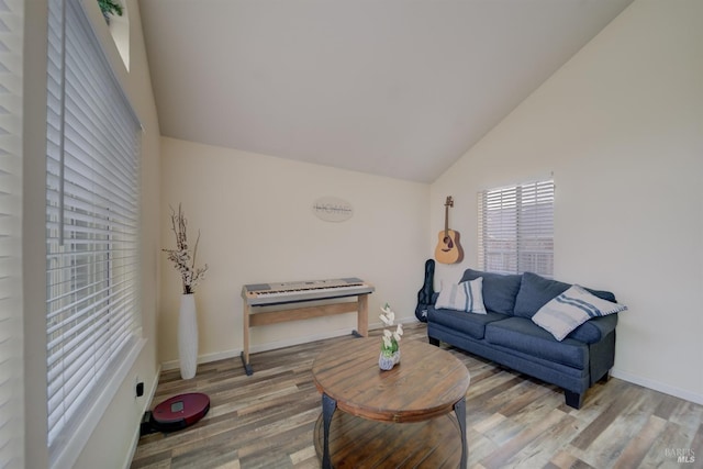 living room with lofted ceiling, wood finished floors, and baseboards