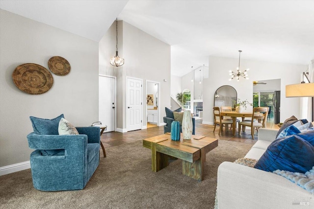 living room with high vaulted ceiling, an inviting chandelier, and baseboards