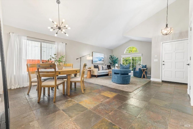 dining area with stone tile floors, baseboards, an inviting chandelier, and high vaulted ceiling